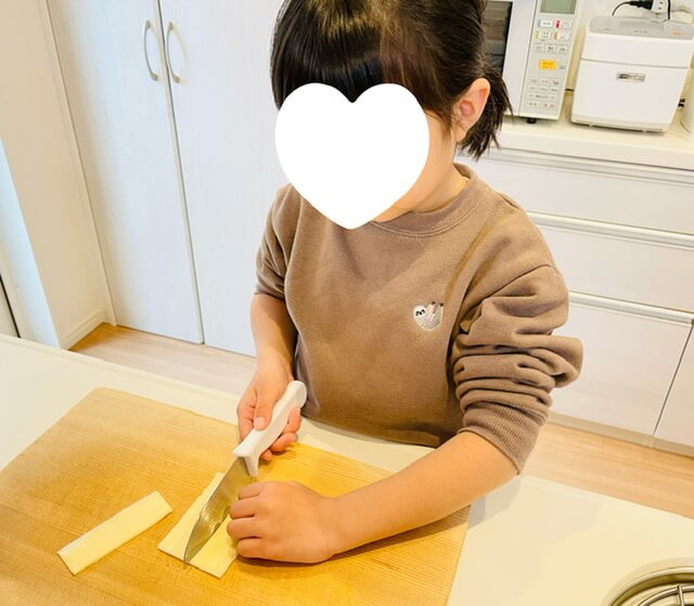 ギザギザ刃の子供用包丁でチーズを切る